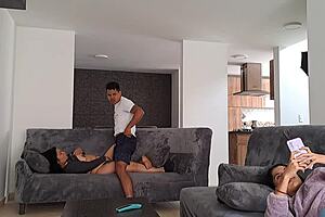 Horny mature woman masturbates on sofa while stepdaughter distracts