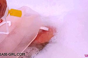 Enchanting brunette muse relaxes in a sensual bath on the sofa