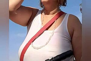 Far out! This sexy African milf flashes big natural tits and pussy lips on the beach.