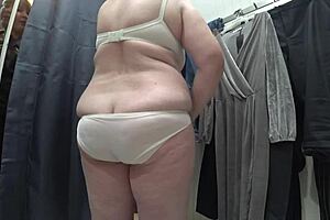 a plump milf with juicy ass in white panties and big tits in bra caught on hidden camera in public dressing room