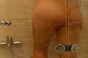 The busty milf with big tits and ass indulges in sensual caresses in the steamy bath.