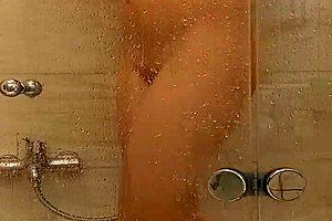The busty milf with big tits and ass indulges in sensual caresses in the steamy bath.