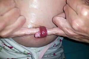 Nippleringlover, the kinky milf, fingers her extreme stretched nipple piercing. She pushes two fingers through while in bdsm slave mode.