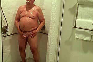 Grandpa indulges in a steamy shower, revealing unexpected allure.