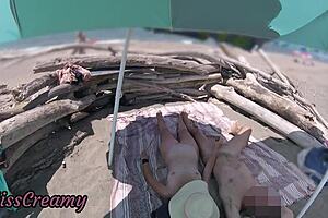 Exhibitionist wife gives outdoor amateur milf handjob to big cock on nudity beach in front of voyeur with cumshot