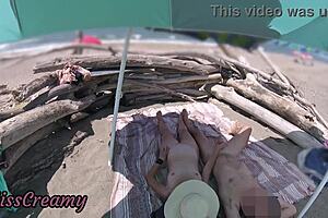 Exhibitionist wife gives outdoor amateur milf handjob to big cock on nudity beach in front of voyeur with cumshot