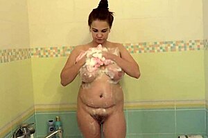 A pretty milf bathes showing big tits hairy pussy ass